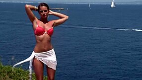 Girl in bikini strips by the cliff in hot scene.