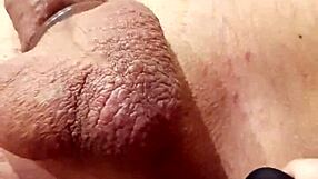 Wife inserts small toy into husband's ass during close-up anal play session
